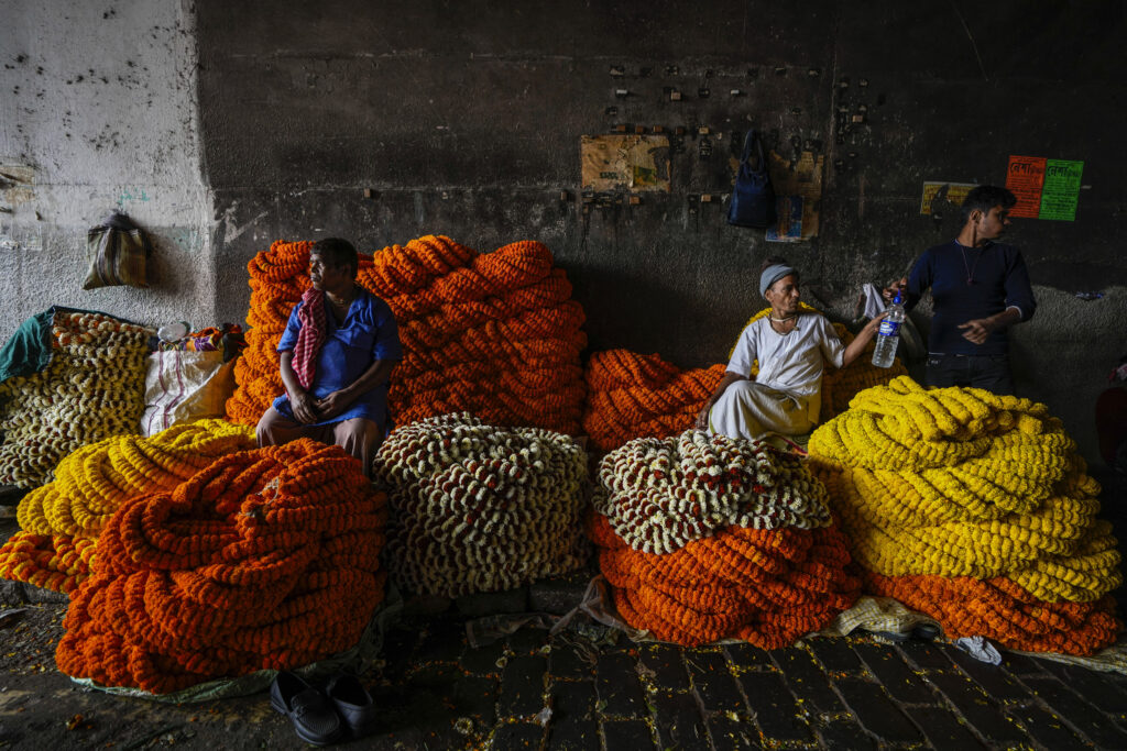 KOLKATA — Living with bright colors, a national trait: Vendors with marigold garlands await customers at a wholesale flower market in Kolkata, India, Thursday, Feb. 22, 2024.Photo: Bikas Das/AP