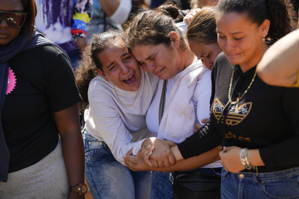 VENEZUELA — Mourning family loss in a mine collapse: A sister of miner Santiago Mora, left, cries with other relatives as he is buried at the cemetery in La Paragua, Bolivar state, Venezuela, Thursday, Feb. 22, 2024. The collapse of an illegally operated open-pit gold mine in central Venezuela killed at least 14 people and injured several more, state authorities said Wednesday, as some other officials reported an undetermined number of people could be trapped.Photo: Ariana Cubillos/AP