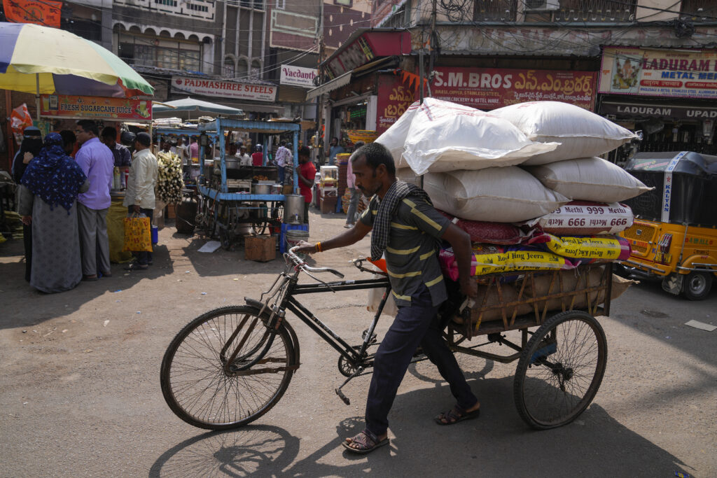INDIA — Everyone does what they can to hold on a little longer and make ends meet: A rickshaw puller transports a load at a wholesale market in Hyderabad, India, Thursday, Feb. 1, 2024. India’s finance minister unveiled on Thursday a short-term budget to meet government expenditures until national elections are held by May.Photo: Mahesh Kumar A./AP