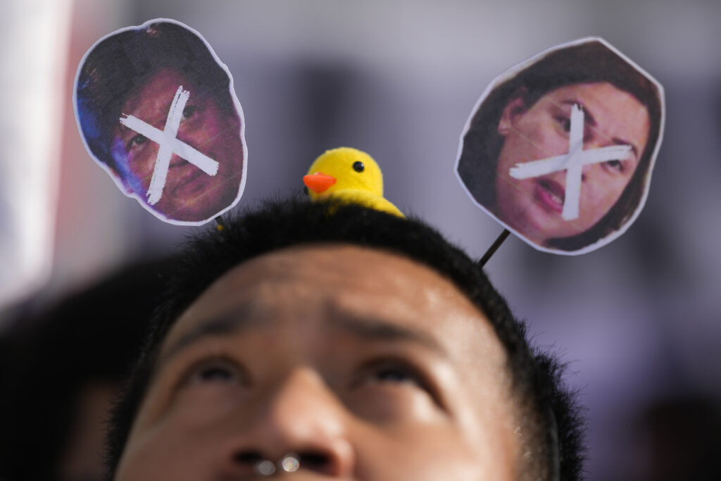MANILA — Headband antennae art making a political statement: A protester looks at the crossed-out images of Philippine President Ferdinand Marcos Jr., left, and Vice-President Sara Duterte as he joins a protest on Thursday, Feb. 22, 2024, in Manila, Philippines. They protested against a plan by some lawmakers to change parts of the constitution.Photo: Aaron Favila/AP