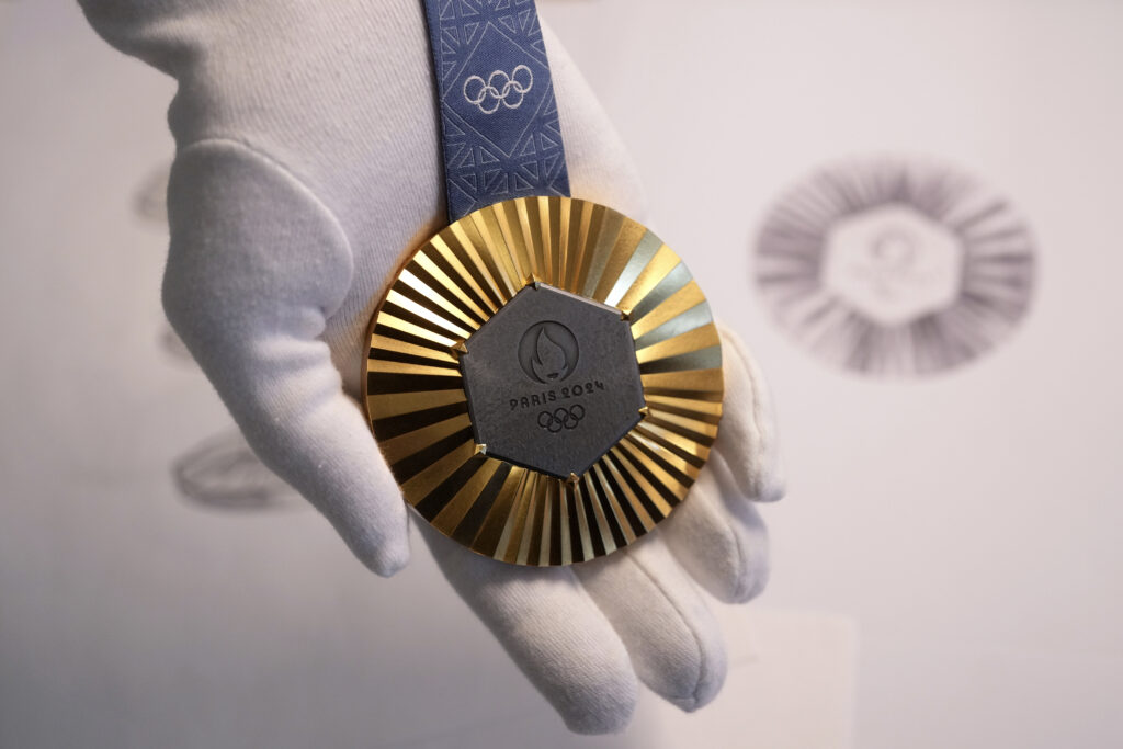 PARIS — ‘Careful when taking metal pieces from the Eiffel Tower…’: The Paris 2024 Olympic gold medal is presented to the press in Paris, Thursday, Feb. 1, 2024. A hexagonal, polished piece of iron taken from the Eiffel Tower is being embedded in each gold, silver and bronze medal that will be hung around athletes' necks at the July 26-Aug. 11 Paris Games and Paralympics that follow.Photo: Thibault Camus/AP