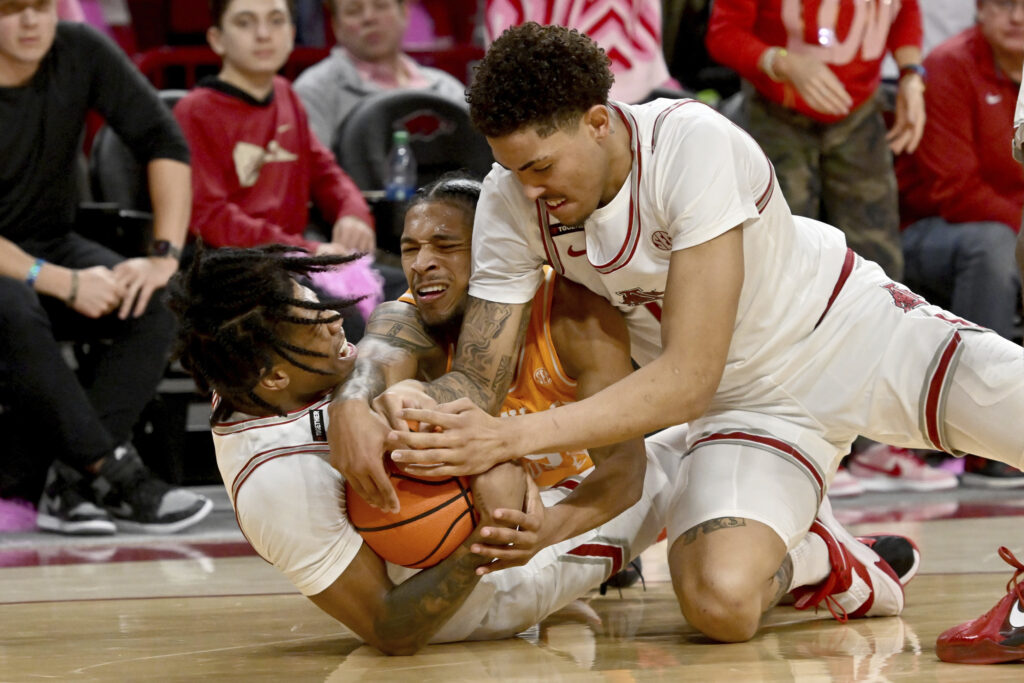 ARKANSAS — ‘Gimme the ball, gimme the ball, gimme the ball’: Arkansas players Khalif Battle, left, and Jalen Graham, right, and Tennessee guard Zakai Zeigler scramble for control of the ball during the first half of an NCAA college basketball game Wednesday, Feb. 14, 2024, in Fayetteville, Ark.Photo: Michael Woods/AP