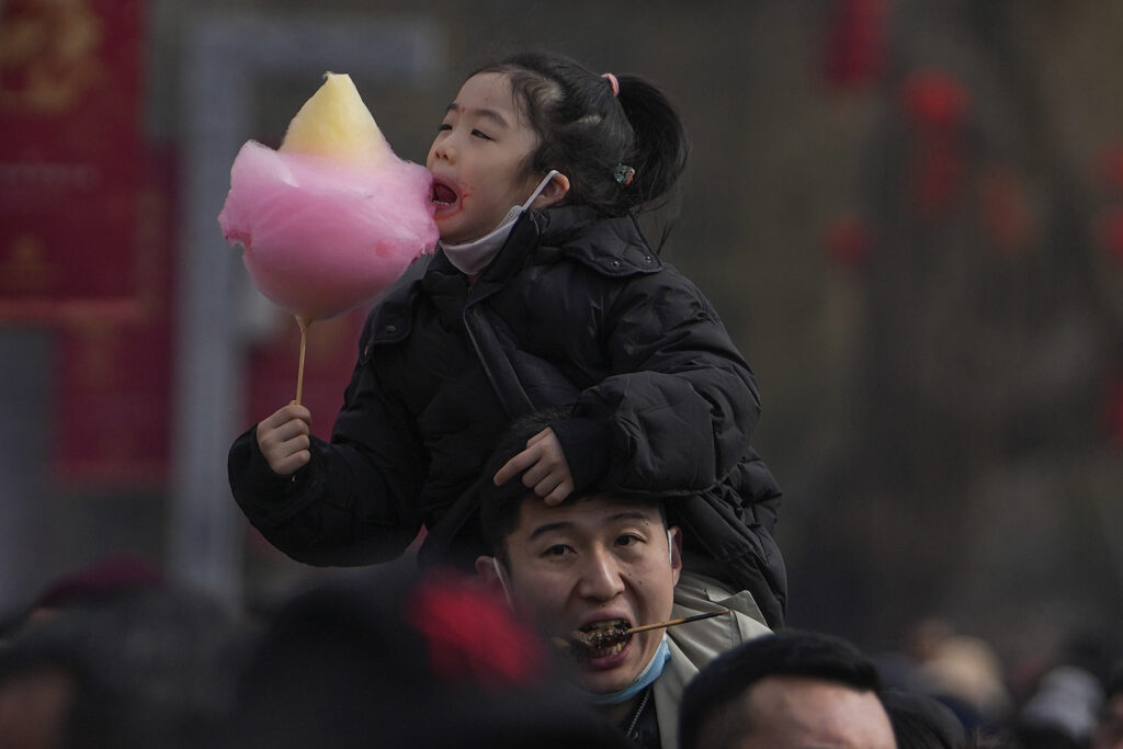 BEIJING — Multigenerational celebrations… with food: A man carries his child on his shoulder as they visit Longtan Park's temple fair during the second day of Lunar New Year celebrations in Beijing, Sunday, Feb. 11, 2024.Photo: Andy Wong/AP