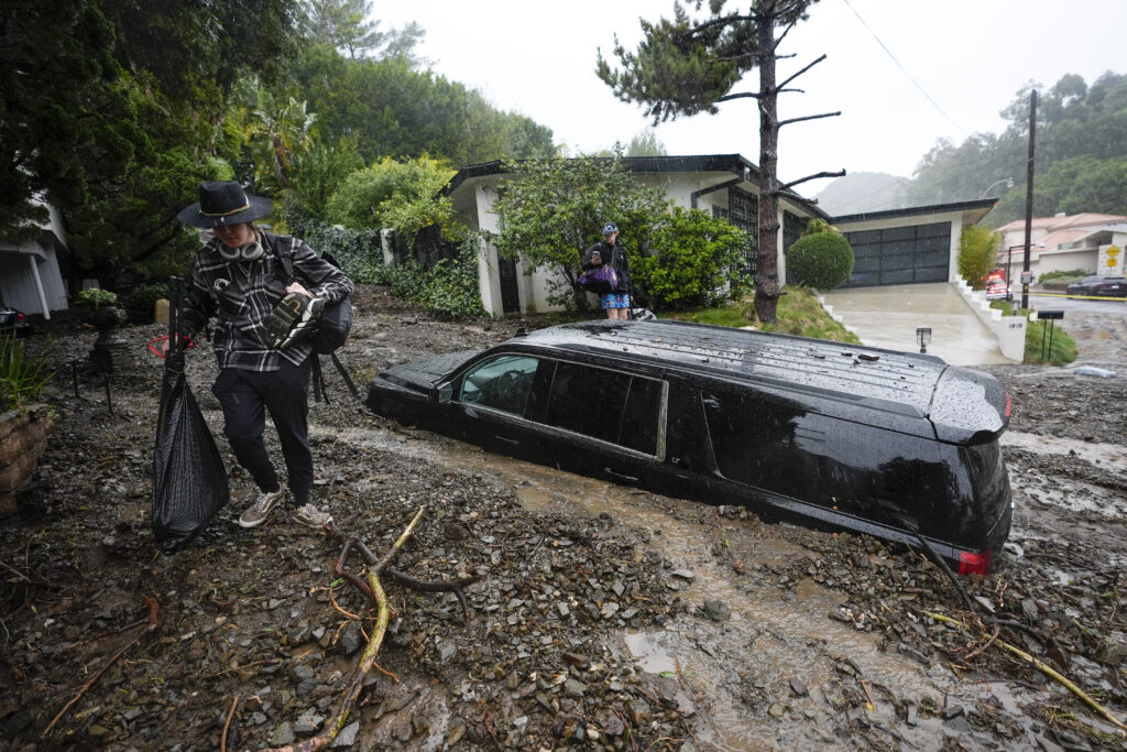 Los Angeles — Nature’s revenge: Another ‘historic’ storm causes over 300 mudslides: Residents evacuate past damaged vehicles after storms caused a mudslide, Monday, Feb. 5, 2024, in the Beverly Crest area of Los Angeles. A storm of historic proportions unleashed record levels of rain over parts of Los Angeles on Monday, endangering the city’s large homeless population, sending mud and boulders down hillsides dotted with multimillion-dollar homes and knocking out power for more than a million people in California.Photo: Marcio Jose Sanchez/AP