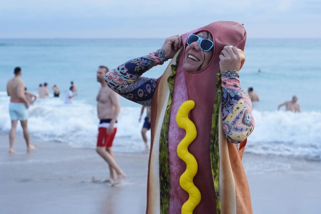 FLORIDA — Ceremonies, no matter what the subject, are definitely the ‘brainchild’ of humans: Christina Lusk of Fort Lauderdale adjusts her wet hotdog costume as she emerges from the ocean during a Groundhog Day celebration in Hollywood, FL, just after dawn on Friday, Feb. 2, 2024. Hollywood's version of Punxsutawney Phil saw his shadow and predicted "six more weeks of tourism" for the area before dozens of celebrants sang the national anthem, then ran into the ocean as part of a local Groundhog Day tradition that dates back twenty years.Photo: Rebecca Blackwell/AP