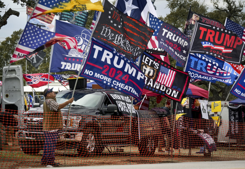 TEXAS — Flags for sale in Dripping Springs: Rudy Martinez, of San Antonio, sets up his flags for sale at the Take Our Border Back Convoy in Dripping Springs, Texas, on Thursday, Feb. 1, 2024.Photo: Jay Janner/Austin American-Statesman via AP