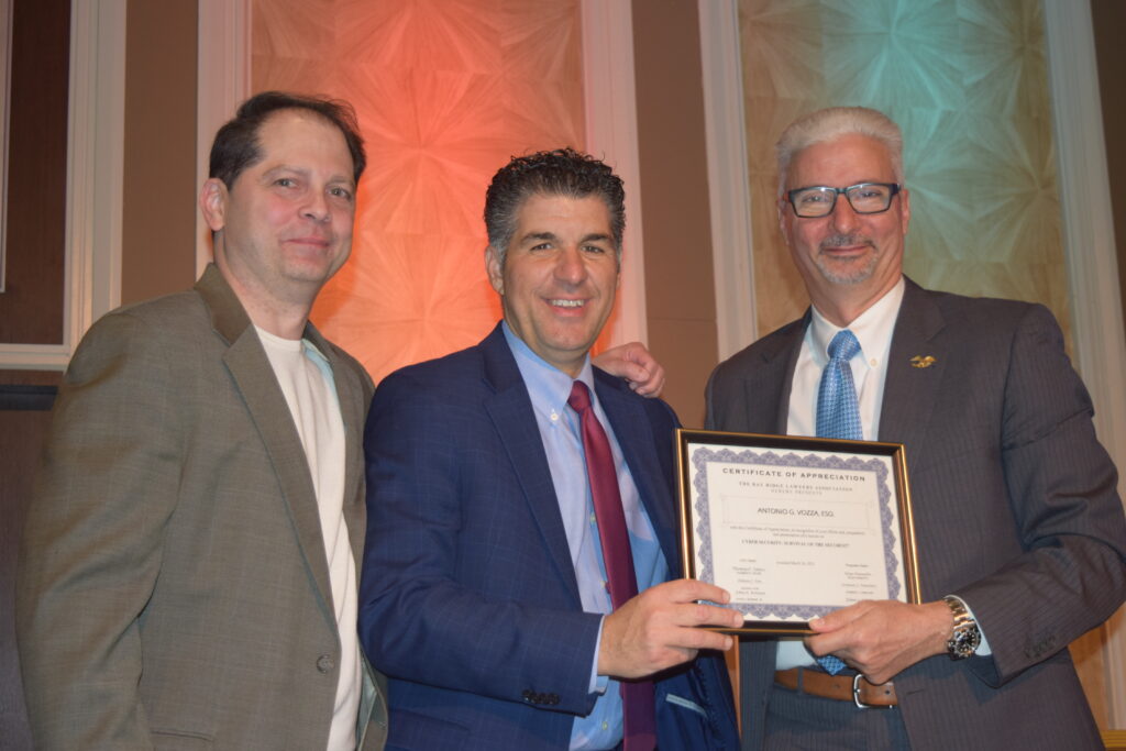 Antonio Vozza receives a certificate of appreciation from Bay Ridge Lawyers Association past presidents Dominic Famulari (center) and Stephen Chiaino (left) for his contributions to legal education and expertise in title insurance.