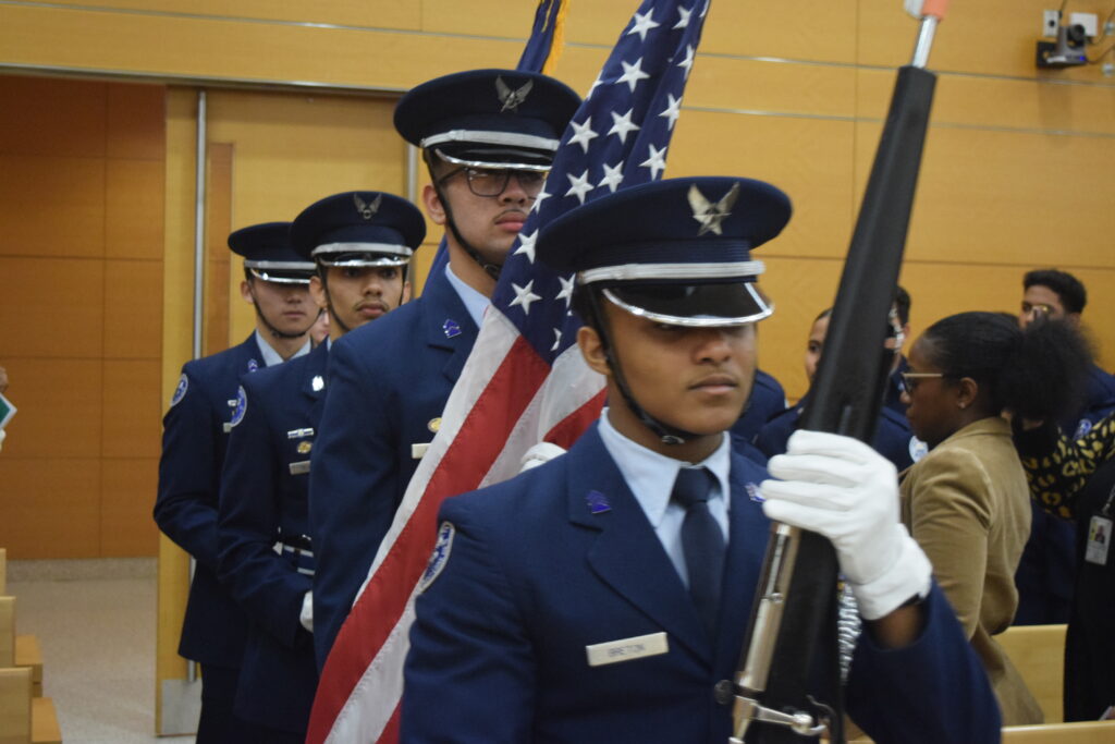 The Elite Color Guard from Franklin K. Lane High School presents colors, marking the start of the event.