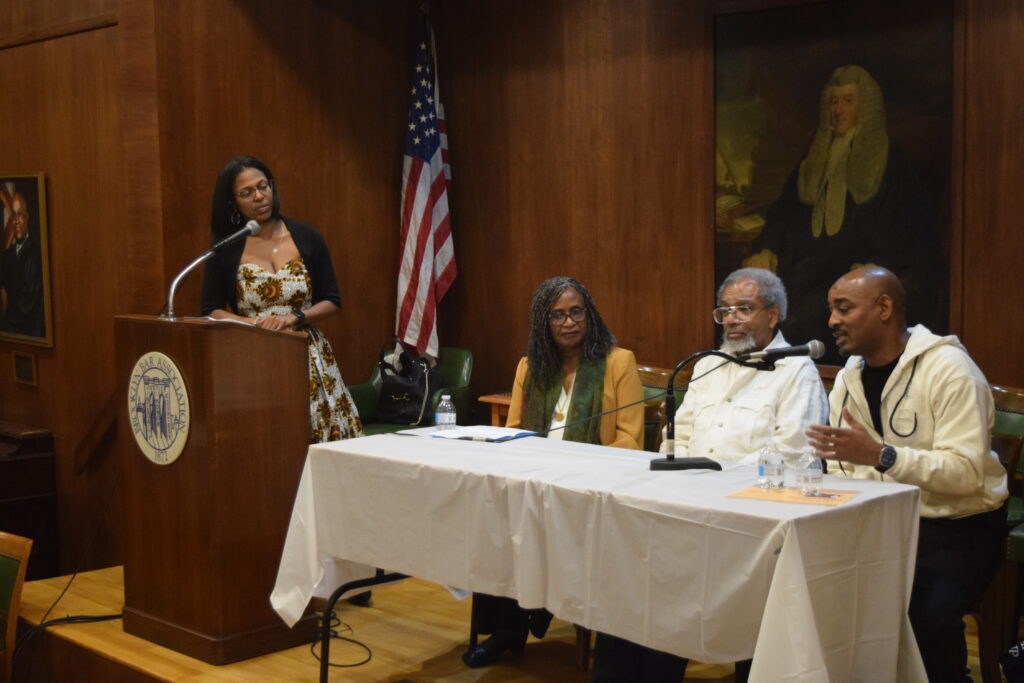 Moderator Karlyne Fequiere stands with seated panelists Dr. Greene, Eric Edwards and Richard Beavers, discussing the arts' pivotal role in Black culture at BWBA Black History Month event.