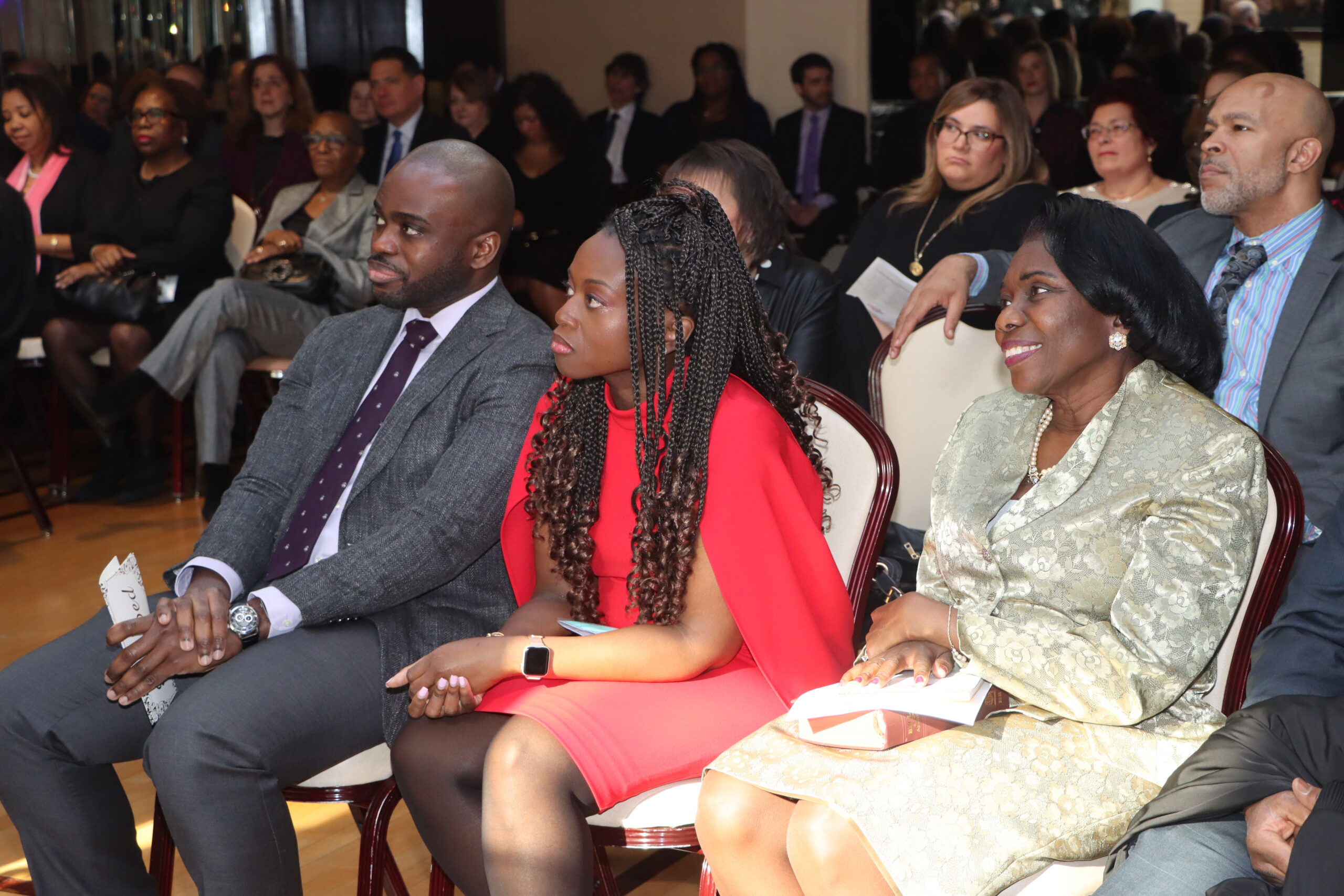 A candid moment with Hon. Betsey Jean-Jacques, sitting closely with her brother Marvin and mother Roseline.