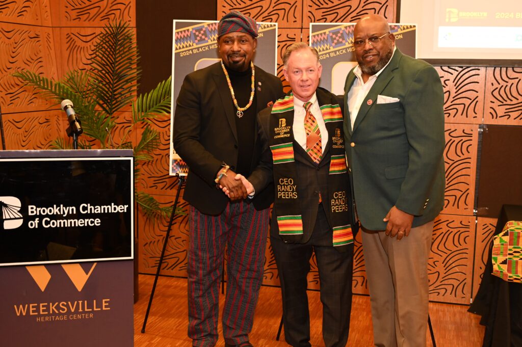 Randy Peers (middle), President and CEO of the Brooklyn Chamber of Commerce, received the Kente cloth from Jerry Kwabena Kansis (left).
