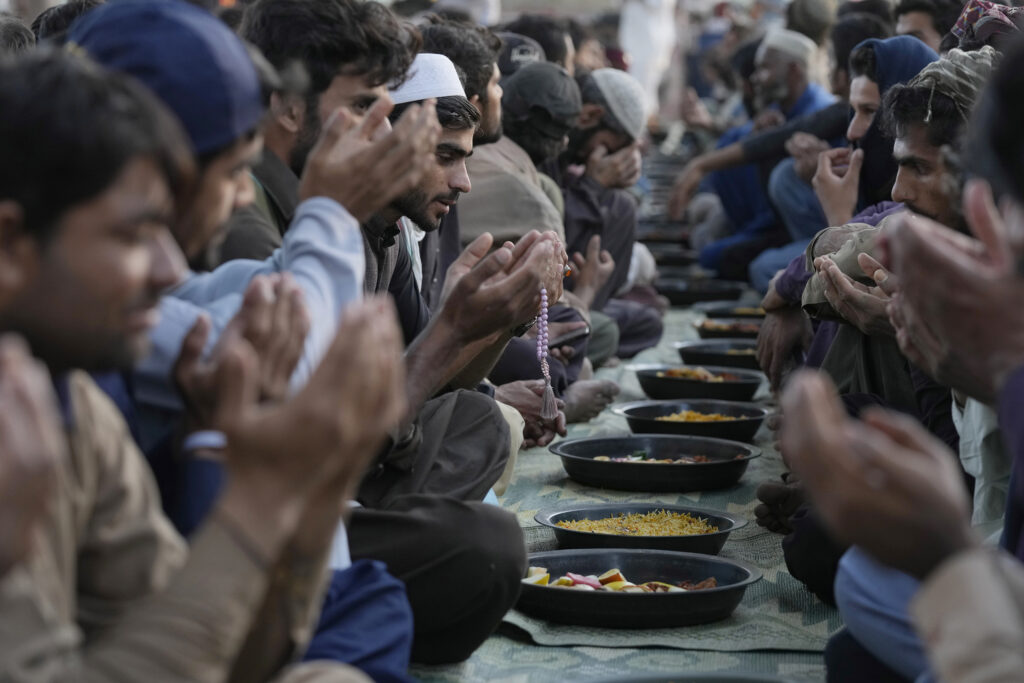 KARACHI — A holy break from the dawn to dusk rite: People pray before breaking their fast during the Muslim's holy fasting month of Ramadan, at a free meal distribution point run by a charity group, in Karachi, Pakistan, Wednesday, March 13, 2024.Photo: Fareed Khan/AP