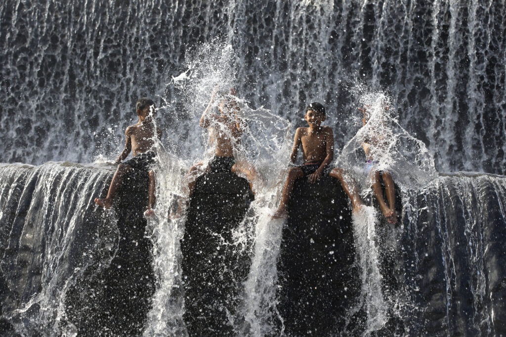 <b>BALI — The Balinese equivalent of a cracked fire hydrant:</b> Residents bathe in a dam of Unda river, ahead of World Water Day, in Klungkung, Bali, Indonesia, Tuesday, March 19, 2024. The Unda River, the second largest river on Bali island, has been used for various activities such as tourism, water rafting and agricultural irrigation.<br>Photo: Firdia Lisnawati/AP
