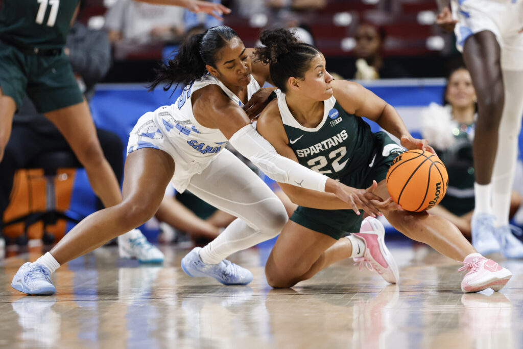 SOUTH CAROLINA — The secret to a good game — make sure there’s only one ball on the court: North Carolina guard Deja Kelly, left, battles Michigan State guard Moira Joiner (22) for a loose ball during the second half of a first-round college basketball game in the women’s NCAA Tournament in Columbia, SC, Friday, March 22, 2024.Photo: Nell Redmond/AP