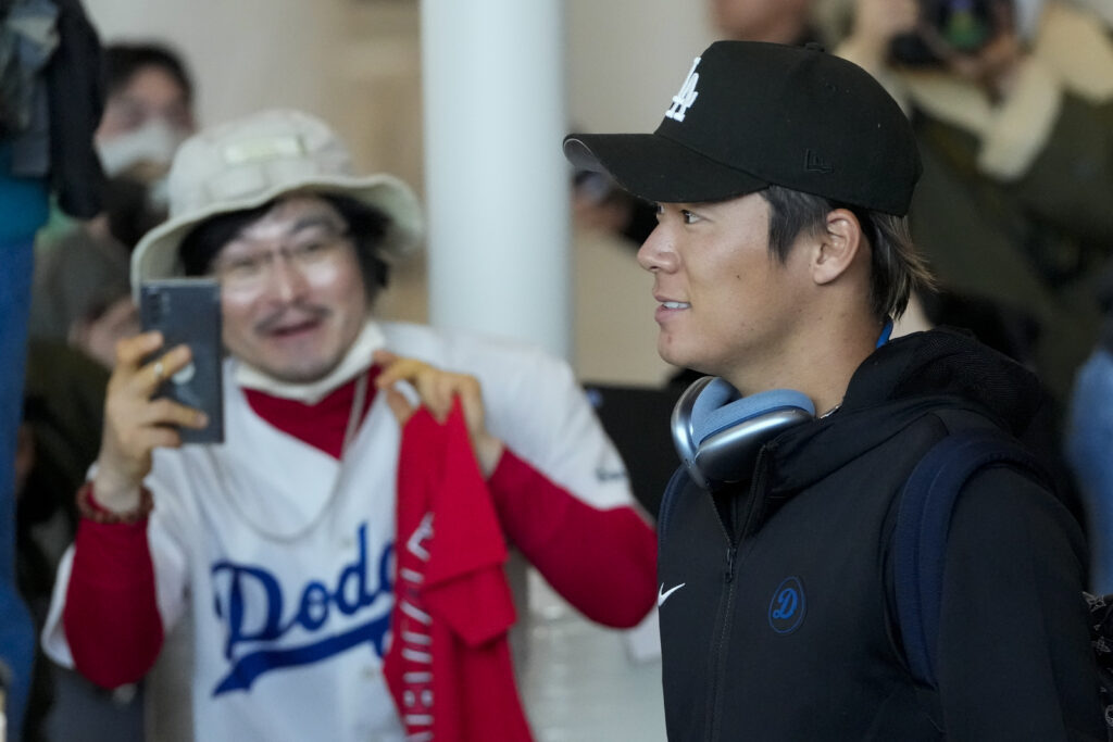 SOUTH KOREA — In U.S. and abroad, fan base competition between Yankees and Dodgers heats up: As indicated by passionate supporter, left, wearing a Los Angeles Dodgers jersey, a new pitcher has put the Dodgers in the lead: Yoshinobu Yamamoto walks by during the baseball team's arrival at Incheon International Airport, Friday, March 15, 2024, in Incheon, South Korea, ahead of the team's baseball series against the San Diego Padres.Photo: Lee Jin-man/AP