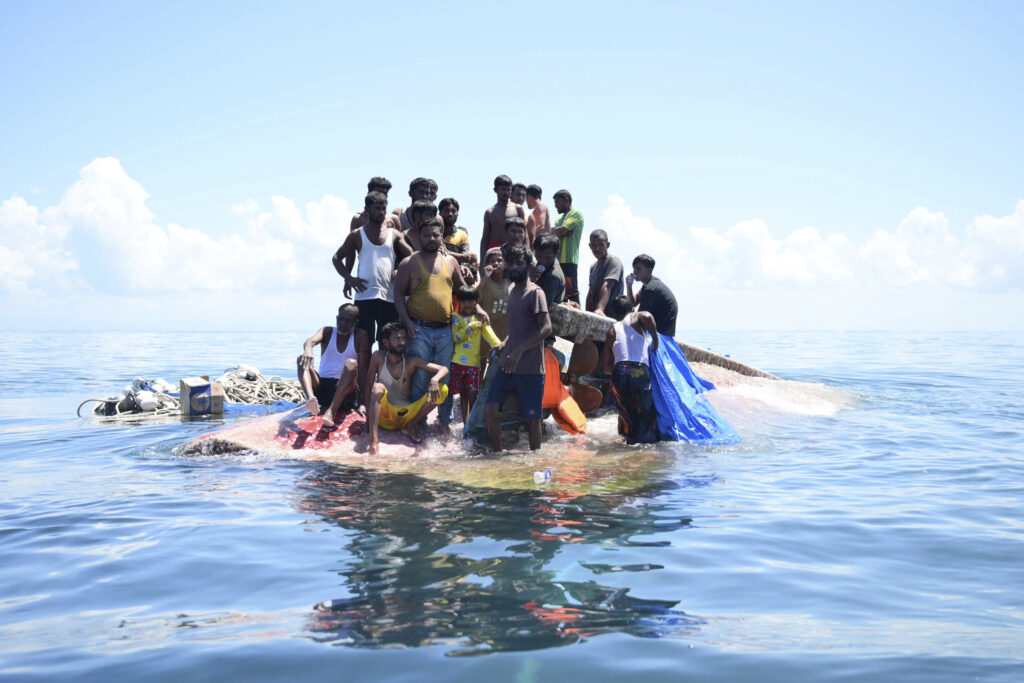 INDONESIA — Myanmar Muslims, heavily persecuted and victims of genocide, escape any way they can: Rohingya refugees stand on their capsized boat before being rescued in the waters off West Aceh, Indonesia, Thursday, March 21, 2024. The wooden boat carrying dozens of Rohingya Muslims capsized off Indonesia's northernmost coast on Wednesday, according to local fishermen.Photo: Reza Saifullah/AP
