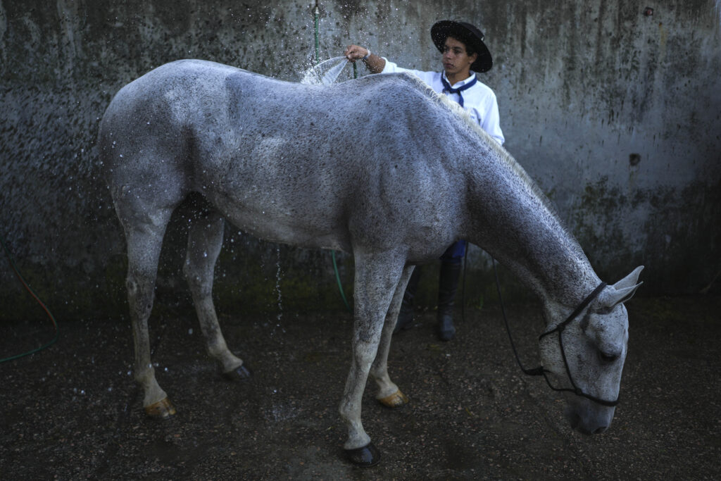 URUGUAY — Getting ready for the rodeo, it’s a hose down! A gaucho, or South American cowboy, bathes a horse during the Criolla Week rodeo festival in Montevideo, Uruguay, on Tuesday, March 26, 2024. The rodeo has been a Holy Week tradition since 1925.Photo: Matilde Campodonico/AP