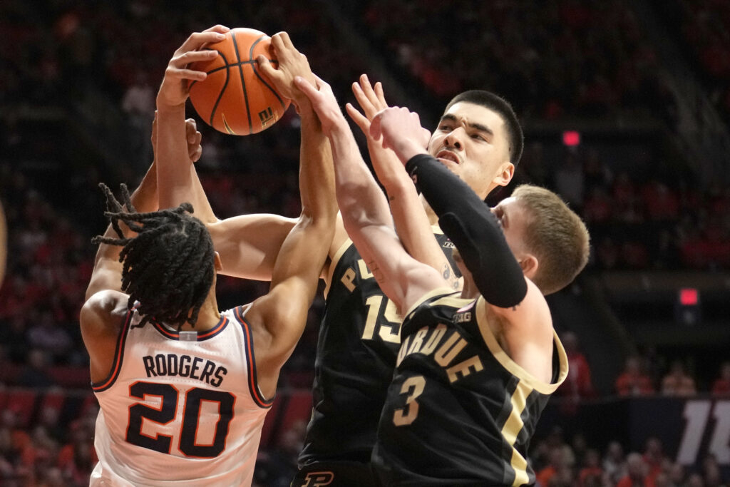 ILLINOIS — ‘Gimme the ball, gimme the ball, gimme the ball’: Illinois’ Ty Rodgers (20) Purdue’s Zach Edey, center, and Braden Smith vie for a rebound during the first half of an NCAA college basketball game Tuesday, March 5, 2024, in Champaign, IL.Photo: Charles Rex Arbogast/AP