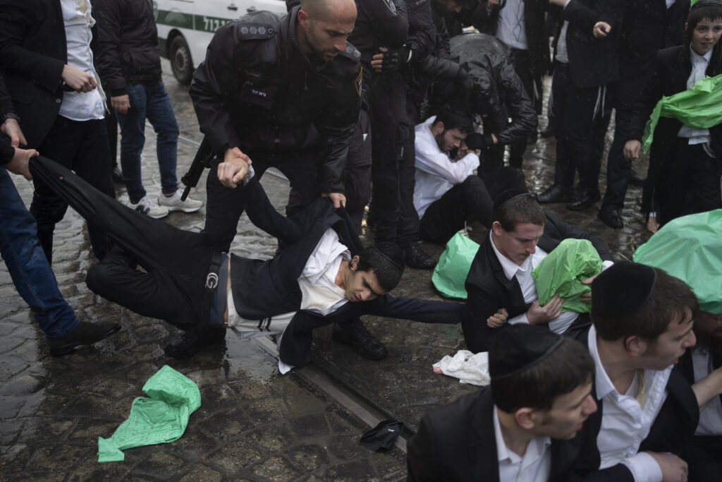JERUSALEM — Political unrest over military service policies: Israeli police officers scuffle with ultra-Orthodox Jewish men during a protest against a potential new draft law that could end their exemptions from military service in Jerusalem, Israel, Monday, March 18, 2024.Photo: Leo Correa/AP