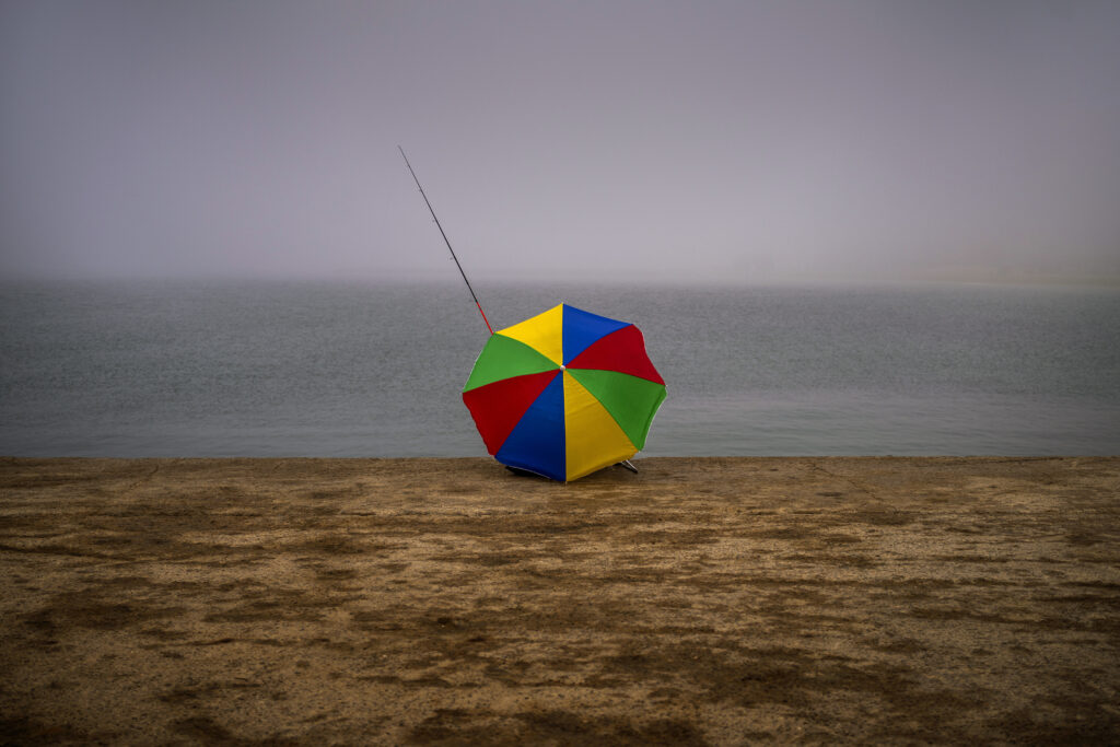 BARCELONA — From a distance, it looked like a beach ball: Francisco Claramunt, 73, uses an umbrella to shelter from the cold wind as he sits fishing on a breakwater on a foggy morning in Barcelona, Spain, Monday, March 18, 2024.Photo: Emilio Morenatti/AP