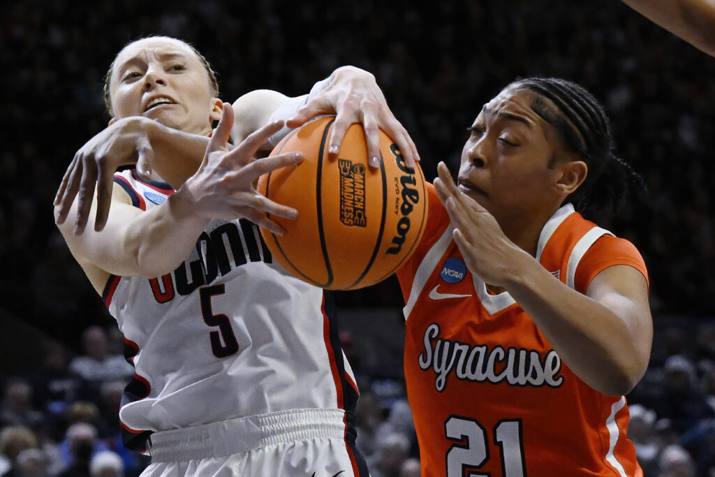 CONNECTICUT — Basketball — sport of hardworking feet and the most dexterous of fingers: UConn guard Paige Bueckers (5) and Syracuse forward Saniaa Wilson (21) reach for a rebound in the first half of a second-round college basketball game in the NCAA Tournament, Monday, March 25, 2024, in Storrs, Conn.Photo: Jessica Hill/AP