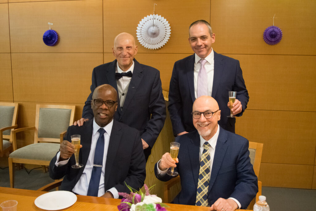 The men of the court toast to the women as well. Pictured clockwise starting top left: Daniel Alessandrino, Brian McAllister, Hon. Richard Montelione and Charles Small, elegantly holding champagne glasses filled with apple cider at SJDEJC Women's History Month.