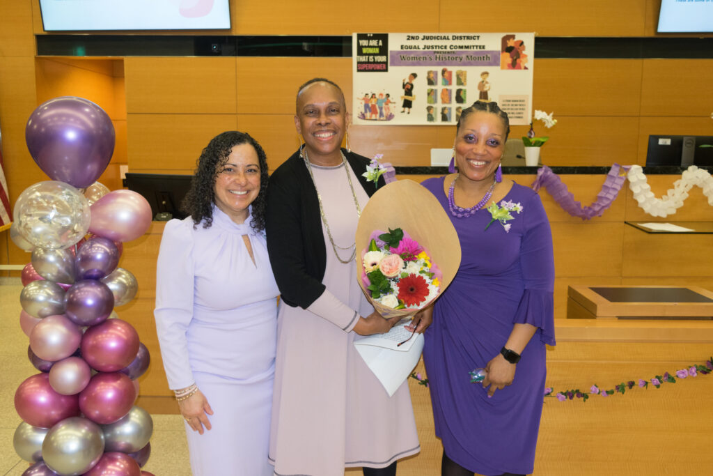 The Second Judicial District Equal Justice Committee hosted an event to commemorate Women's History Month on Friday, March 22. Pictured is Justice Joanne Quinones, alongside Hon. Wavny Toussaint (center) and Taneka Teel, presenting flowers to Toussaint in recognition of her keynote speech at SJDEJC Women's History Month.