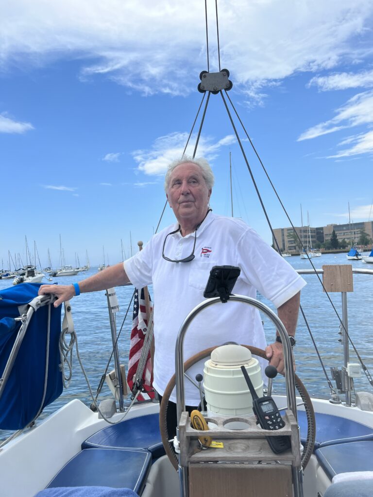 Miramar club member and attorney George Farkas at the helm of his boat, “FOR-PLAY II.”