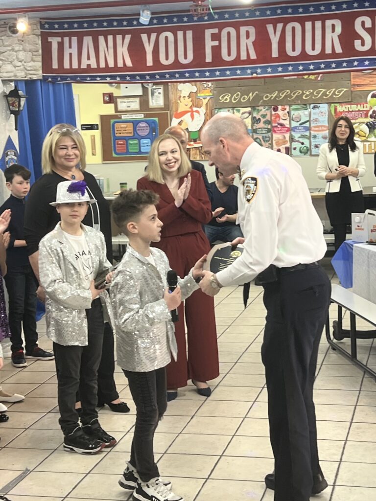 A performer presenting an award to an officer at Big Apple Academy presentation.