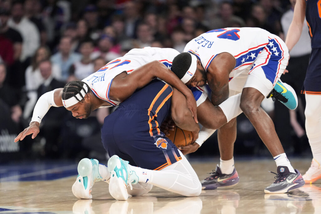 MSG — Somewhere in the middle of this contortion of arms and legs is a live ball: Philadelphia 76ers guard Buddy Hield (17) and forward Paul Reed (44) and New York Knicks forward Precious Achiuwa try to get control of the ball during the first half of an NBA basketball game Tuesday, March 12, 2024, at Madison Square Garden in New York.Photo: Mary Altaffer/AP