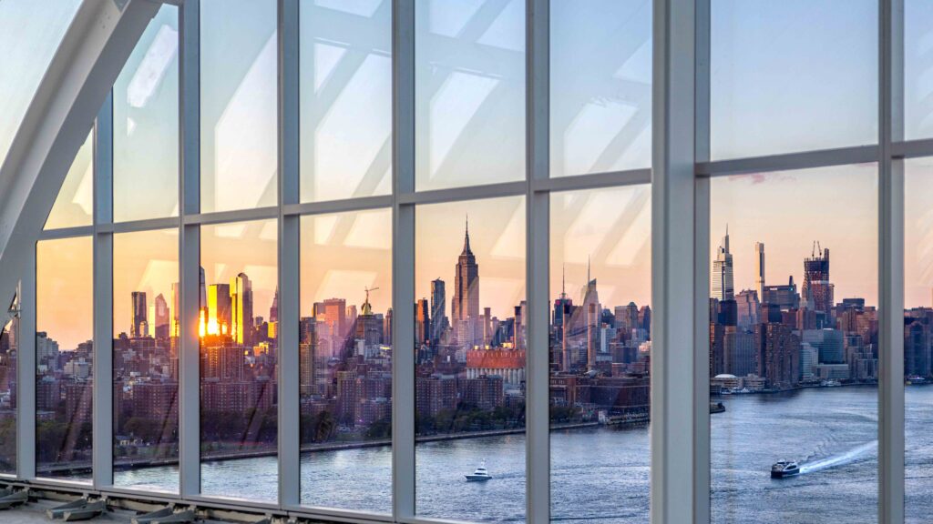Penthouse tenant amenity space at dusk overlooking NYC skyline. Photo by Max Touhey