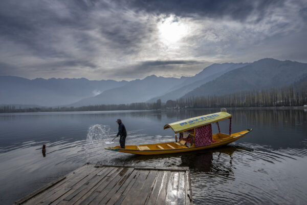 KASHMIR — Quiet moment, peaceful water as boat is docked: A Kashmiri boatman sprays water with his paddle to clean a wooden jetty early morning in Srinagar, Indian-controlled Kashmir, Wednesday, April 3, 2024.Photo: Dar Yasin/AP
