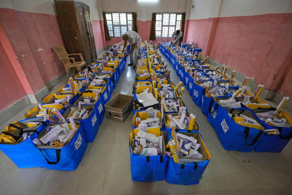 Officials prepare bags of election material to be distributed along with the Electronic Voting Machines (EVMs) ahead of the national parliamentary elections in Jorhat, India, Wednesday, April 17, 2024. (AP Photo/Anupam Nath)