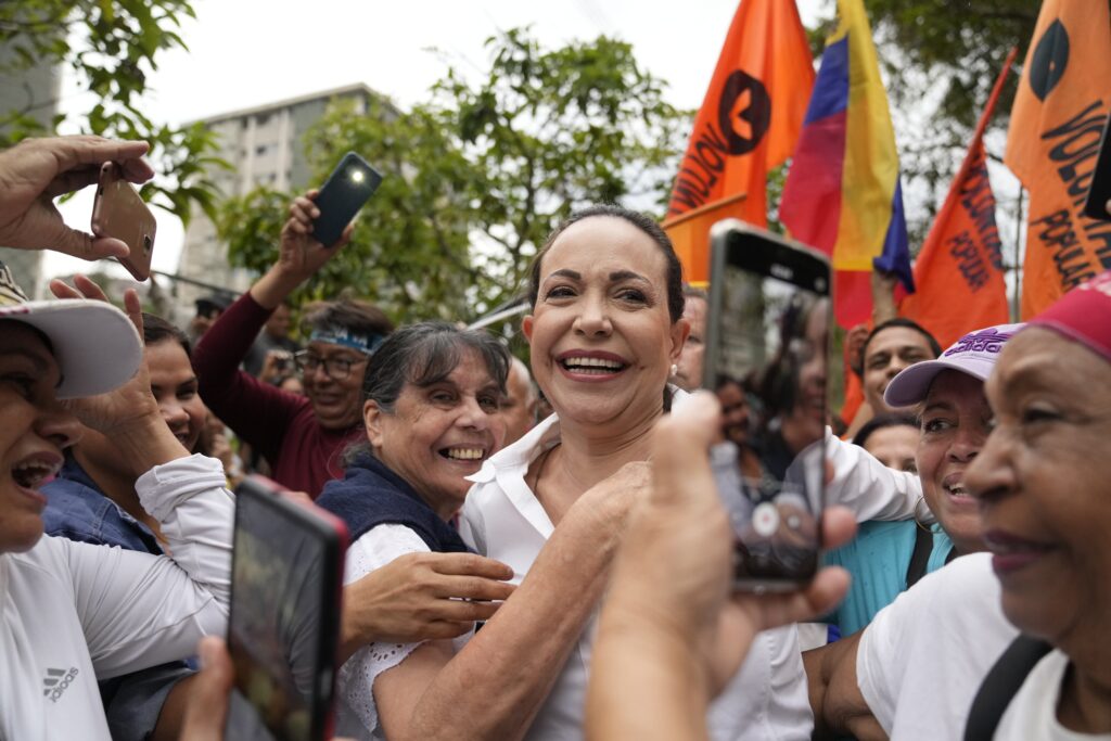 Opposition leader Maria Corina Machado ie embraced by supporters during a rally where she asked them to keep the faith, in San Antonio, Venezuela, Wednesday, April 17, 2024. The Biden administration on Wednesday reimposed oil sanctions on Venezuela, admonishing President Nicolás Maduro's attempts to consolidate his rule, actions that include blocking Machado, his main rival, from registering her candidacy or that of a designated alternative. (AP Photo/Ariana Cubillos)