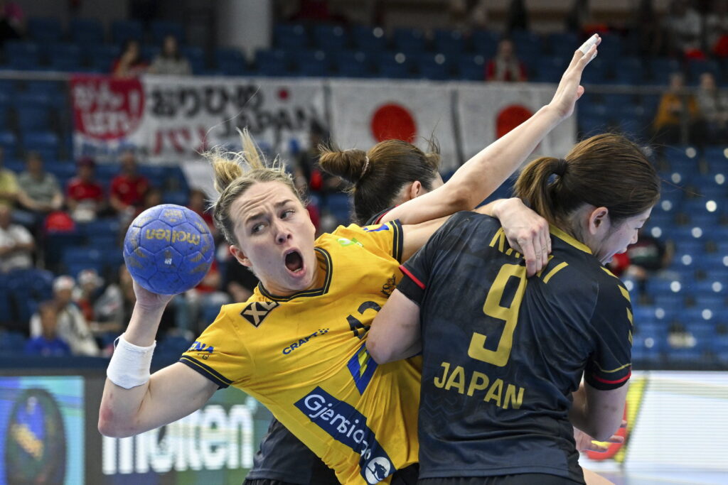 Jenny Karlsson, left, of Sweden is challenged by Chikako Kasai of Japan for the ball at the goal during the Olympic qualification handball match between Sweden and Japan in Debrecen, Hungary, Thursday, April 11, 2024. (Tibor Illyes/MTI via AP)