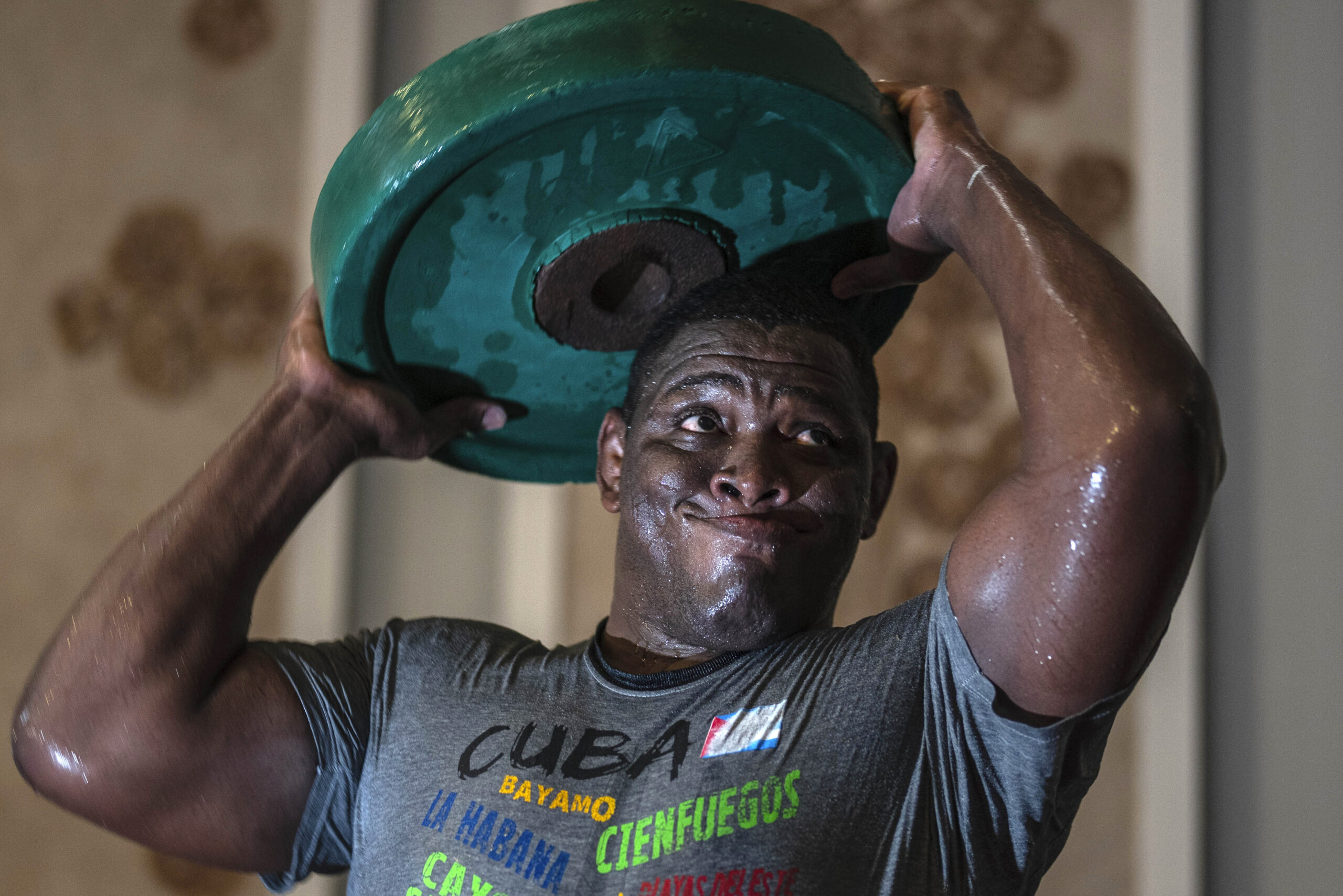 Greco-Roman wrestler Cuba's Mijain Lopez Nunez lifts weights during a training session in Varadero, Cuba, Wednesday, April 3, 2024. Lopez will be part of the Cuban delegation to Paris in pursuit of a fifth Olympic gold to mark the end of his career. (AP Photo/Ramon Espinosa)