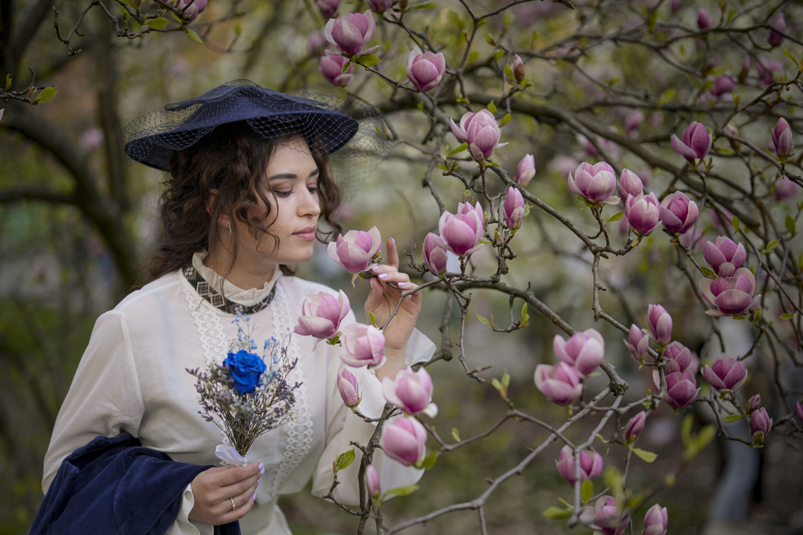 A woman poses for a friend next to blossoming trees in the A.V. Fomin Botanical Garden, in Kyiv, Ukraine, Wednesday, April 10, 2024. (AP Photo/Vadim Ghirda)