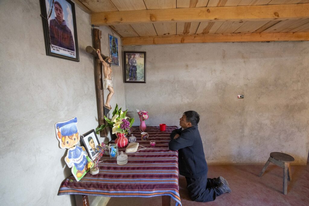 Marco Antulio Pablo Perez prays at an altar for his son Anderson Pablo who died trying to migrate to the U.S. in Comitancillo, Guatemala, Wednesday, March 20, 2024. The 16-year-old died among the migrants who were shot and set afire by rogue police officers in Camargo, Mexico, in January 2021. (AP Photo/Moises Castillo)
