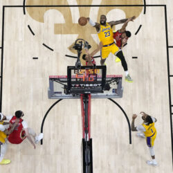 Los Angeles Lakers forward LeBron James (23) shoots between New Orleans Pelicans guard Trey Murphy III and guard CJ McCollum in the second half of an NBA basketball play-in tournament game Tuesday, April 16, 2024, in New Orleans. The Lakers won 110-106. (AP Photo/Gerald Herbert)