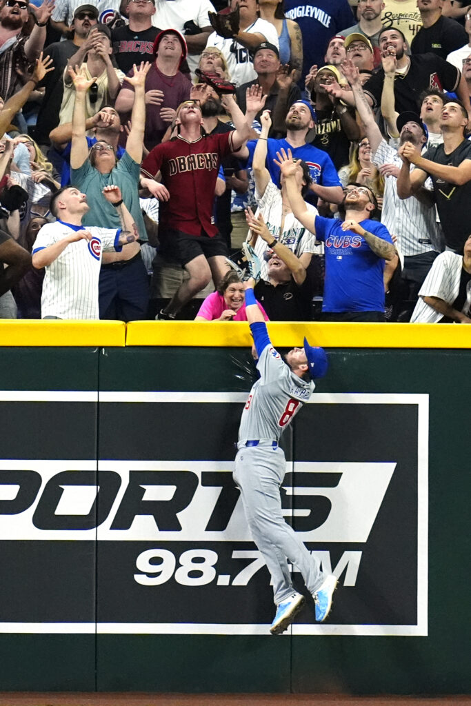 Chicago Cubs left fielder Ian Happ leaps in vain for a two-run home run hit by Arizona Diamondbacks' Lourdes Gurriel Jr. during the third inning of a baseball game Tuesday, April 16, 2024, in Phoenix. (AP Photo/Ross D. Franklin)