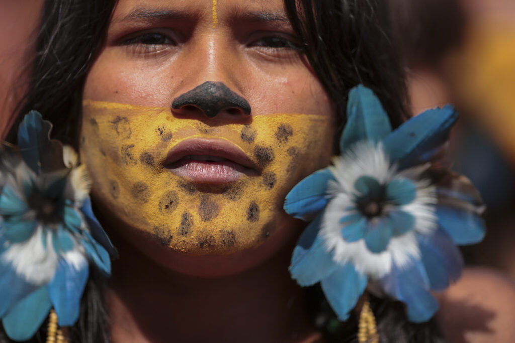 An Indigenous woman attends the 20th annual Free Land Indigenous Camp in Brasilia, Brazil, Monday, April 22, 2024. The 7-day event aims to show the unity of Brazil's Indigenous peoples in their fight for the demarcation of their lands and their rights. (AP Photo/Luis Nova)