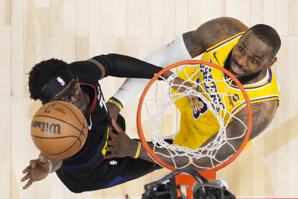 Denver Nuggets guard Reggie Jackson (7) and Los Angeles Lakers forward LeBron James (23) eye the ball during the second half in Game 2 of an NBA basketball first-round playoff series, Monday, April 22, 2024, in Denver. (AP Photo/Jack Dempsey)
