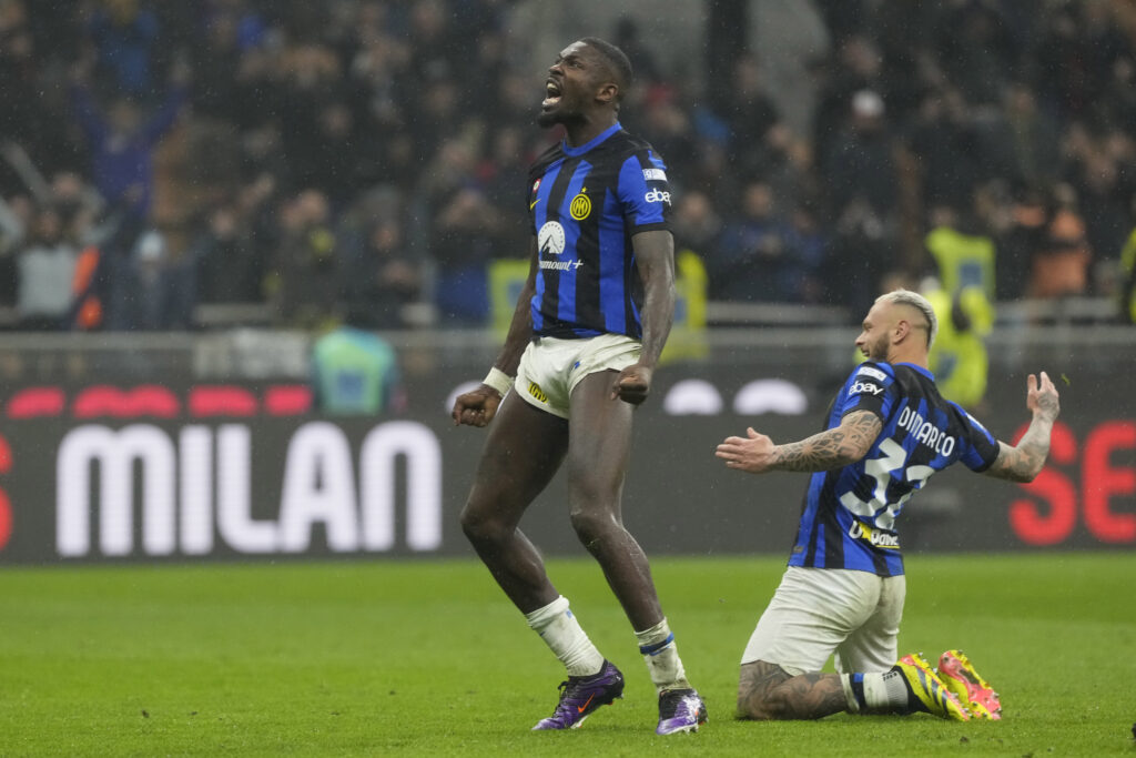 Inter Milan's Marcus Thuram, left, and Inter Milan's Federico Dimarco celebrate at the end of the Serie A soccer match between AC Milan and Inter Milan at the San Siro stadium in Milan, Italy, Monday, April 22, 2024. (AP Photo/Luca Bruno)