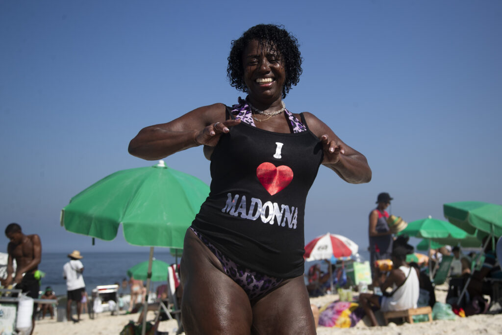 Beachgoer Elizabeth Goncalves shows off her newly bought Madonna T-shirt ahead of Madonna's concert on Copacabana beach in Rio de Janeiro, Brazil, Monday, April 29, 2024. (AP Photo/Bruna Prado)