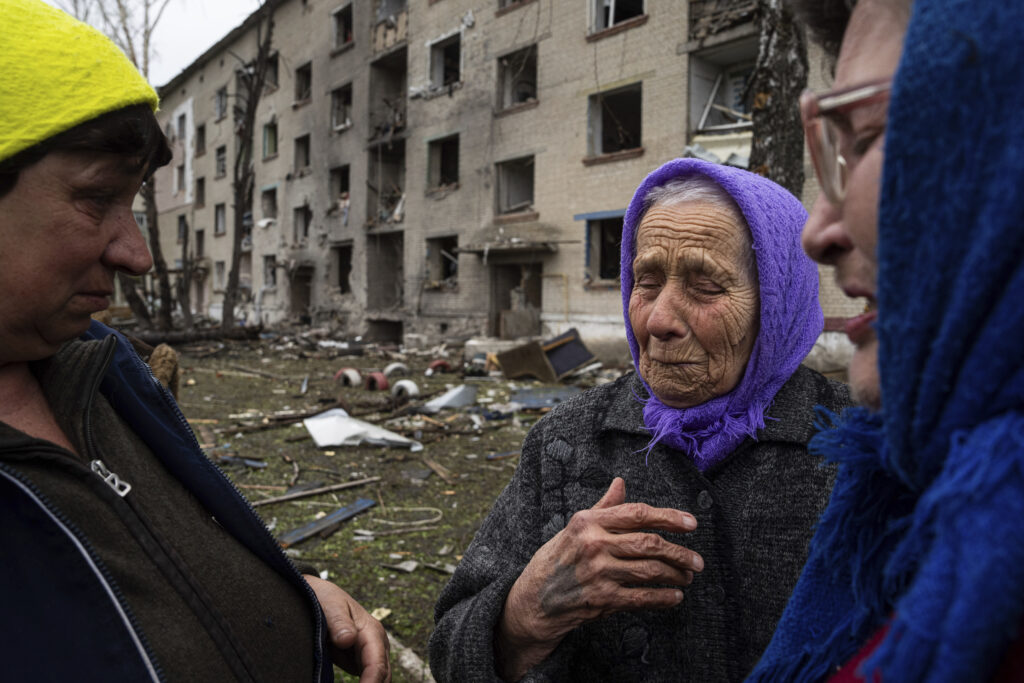 Olga, 79, center, cries as she says goodbye to her neighbors in front of her house which was heavily damaged by a Russian airstrike, during her evacuation, in Lukiantsi, Kharkiv region, Ukraine, on Tuesday, April 16, 2024. (AP Photo/Evgeniy Maloletka)