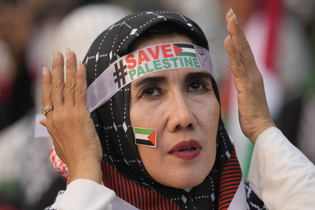 A protester adjusts her headband during a rally and prayer in support of the Palestinians in Gaza, in Jakarta, Indonesia, Sunday, April 7, 2024. (AP Photo/Dita Alangkara)