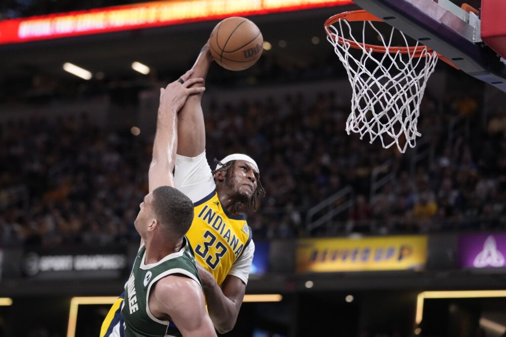 Indiana Pacers' Myles Turner (33) dunks against Milwaukee Bucks' Brook Lopez (11) during the second half of Game 4 of the first round NBA playoff basketball series, Sunday, April 28, 2024, in Indianapolis. (AP Photo/Michael Conroy)