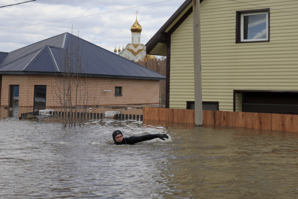 A local resident swims in the flooded street between houses in Orenburg, Russia, on Saturday, April 13, 2024. Over 11,700 houses remain flooded in the Orenburg region and some 10,700 people have already been evacuated from flooded areas. The deluge hit the region after a dam on the Ural River burst last week under surging waters. (AP Photo)