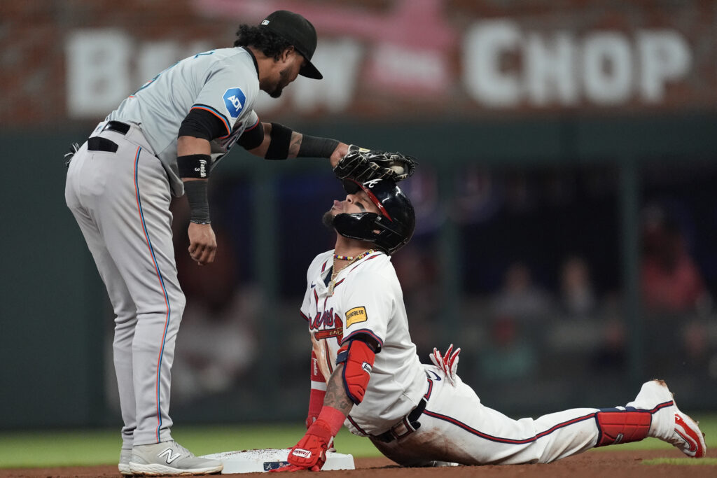 Atlanta Braves' Orlando Arcia is playfully tagged on the head by Miami Marlins second base Luis Arraez (3) after sliding into second base with a double in the seventh inning of a baseball game Monday, April 22, 2024, in Atlanta. (AP Photo/John Bazemore)