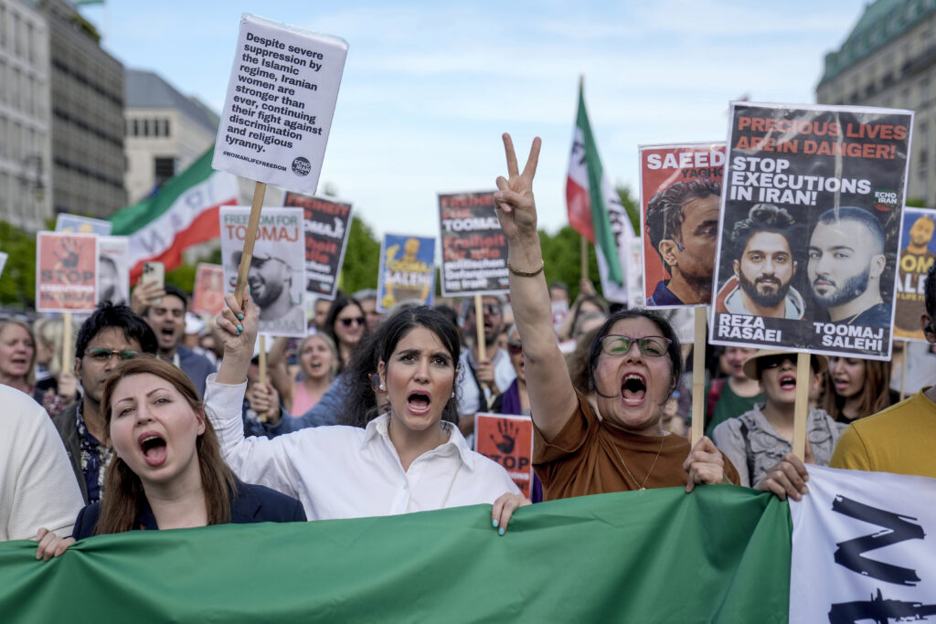 Protesters attend a rally against a death sentence given to a popular rapper in Iran and to support to the women of Iran, in Berlin, Germany, Sunday, April 28, 2024. Toomaj Salehi a 33-year-old was sentenced to death by an Iranian court earlier this week for his support of the Woman, Life, Freedom movement, which developed after protests in Iran in 2022. (AP Photo/Ebrahim Noroozi)